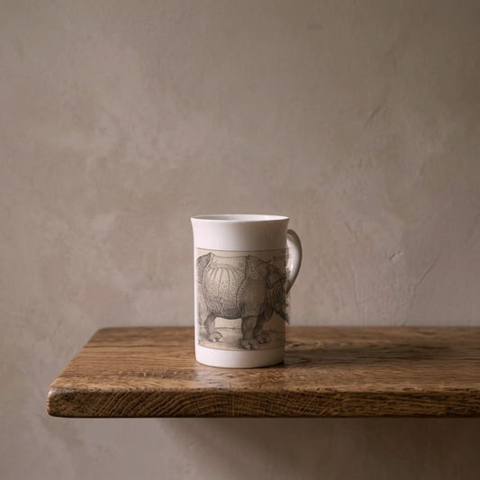 Albrecht Dürer: The Rhinoceros, 1515 – porcelain art mug on an oiled oak shelf against a limewashed wall