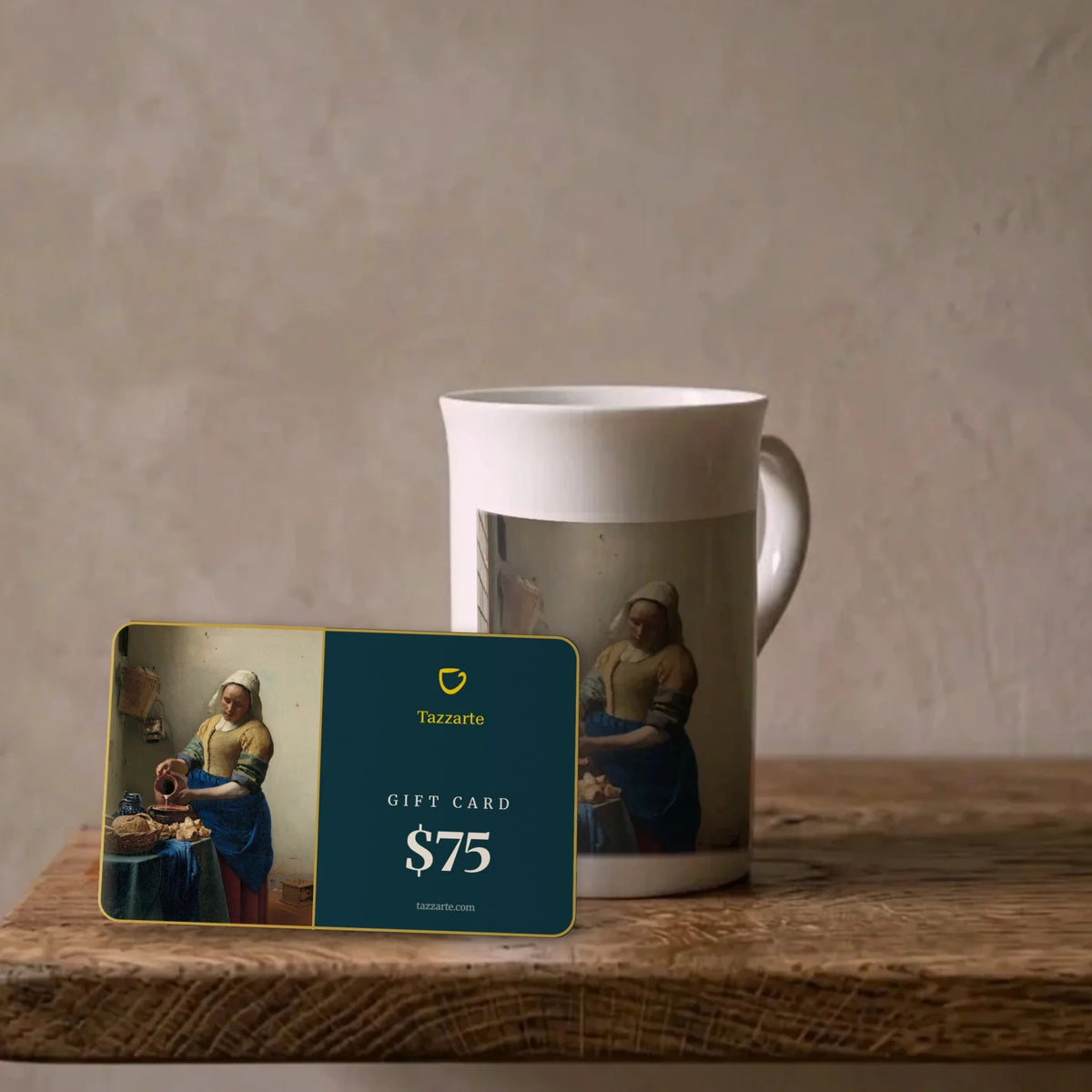 Tazzarte-Kunstgeschenkkarte über $75 mit Vermeers Milchmädchen neben der passenden Kunsttasse aus Porzellan auf einem Eichenregal