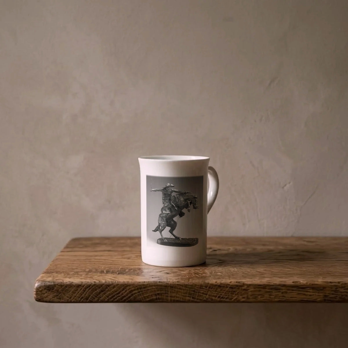 Frederic Remington: The Broncho Buster, 1895 – porcelain art mug on an oiled oak shelf against a limewashed wall