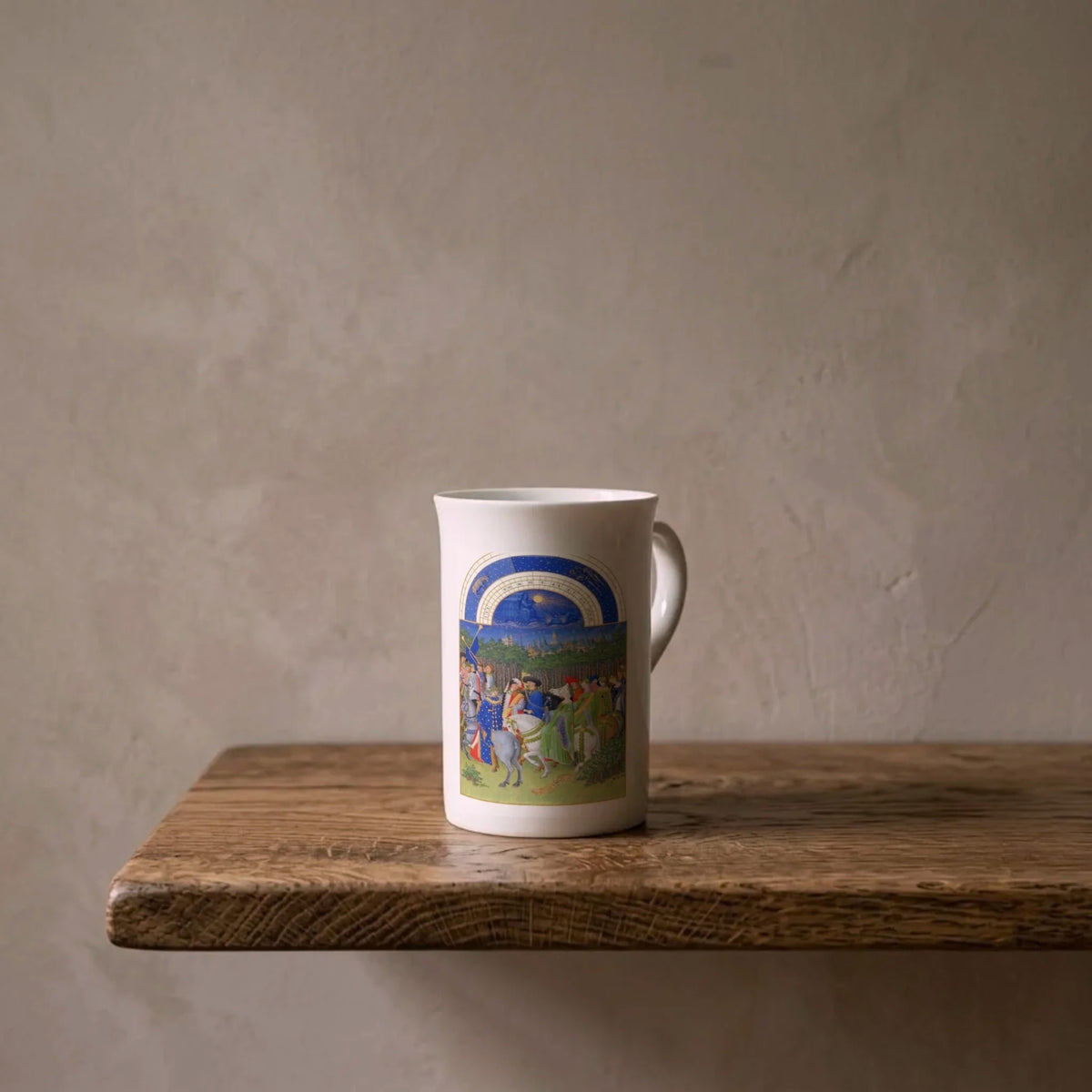 Limbourg Brothers: Très Riches Heures (May), 1416 – porcelain art mug on an oiled oak shelf against a limewashed wall