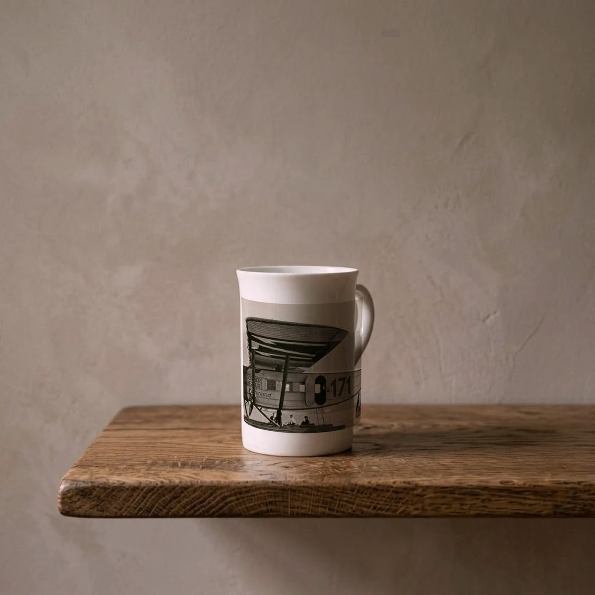 The ‘Switzerland’ porcelain art mug standing on an oiled oak shelf against a limewashed wall